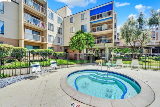 view of swimming pool with a patio and a hot tub