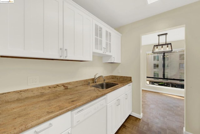 kitchen with light stone counters, pendant lighting, sink, white cabinetry, and dishwasher