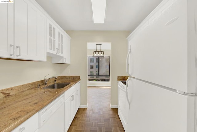 kitchen featuring sink, white cabinets, hanging light fixtures, white appliances, and light stone countertops