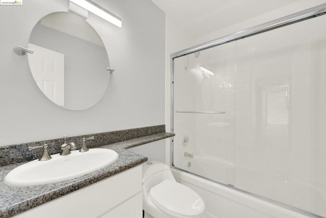 full bathroom featuring bath / shower combo with glass door, toilet, and vanity