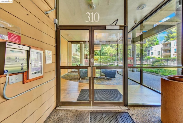 doorway to outside featuring wooden walls