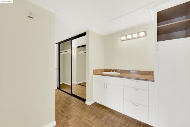 bathroom with parquet floors and vanity