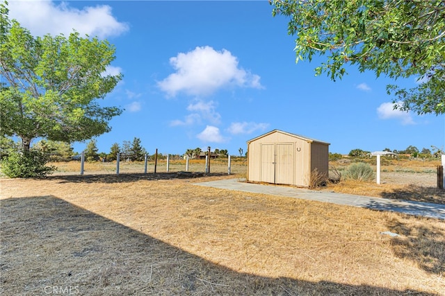 view of yard with a storage shed and a rural view