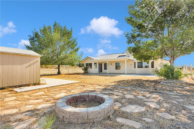 back of property with a patio and a fire pit