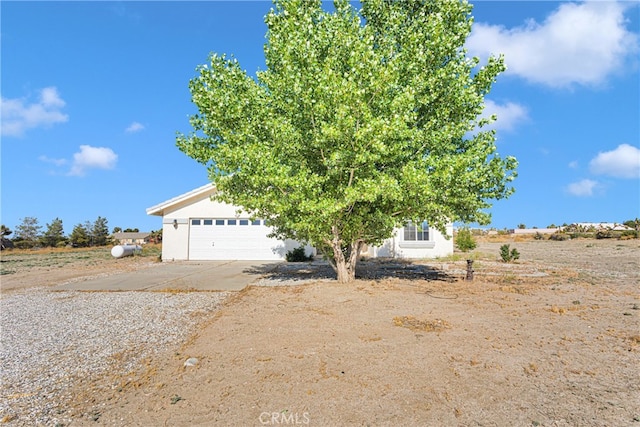 view of property hidden behind natural elements featuring a garage