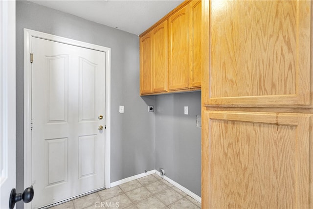 clothes washing area featuring electric dryer hookup, cabinets, and light tile patterned flooring