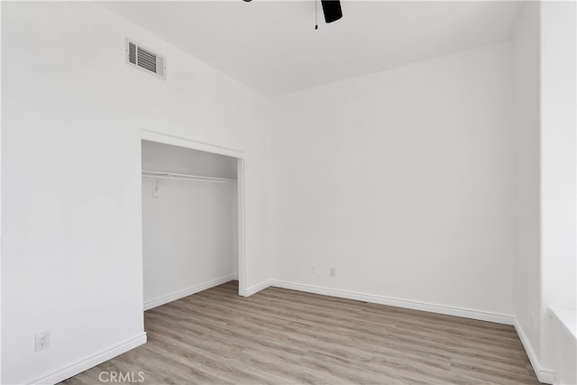 unfurnished bedroom featuring a closet, light hardwood / wood-style floors, and ceiling fan