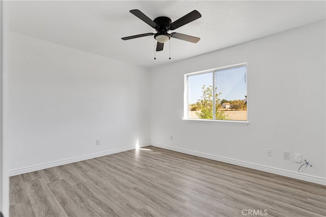 spare room featuring light hardwood / wood-style floors and ceiling fan