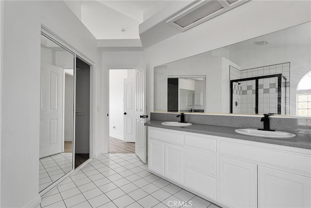 bathroom with vanity, a shower with shower door, and tile patterned flooring