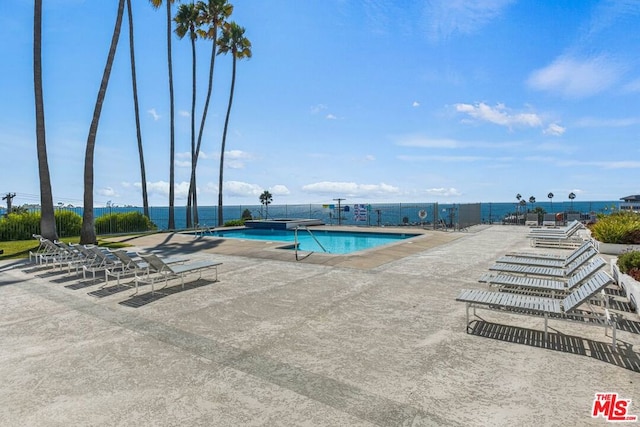 view of swimming pool with a water view and a patio