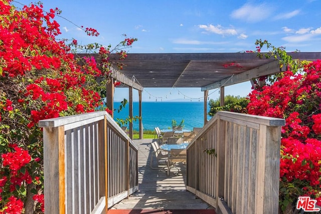 exterior space featuring a pergola and a deck with water view