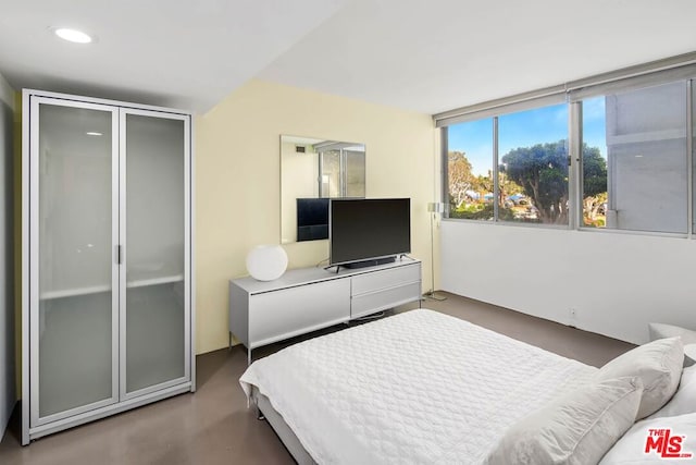 bedroom featuring a closet and concrete floors