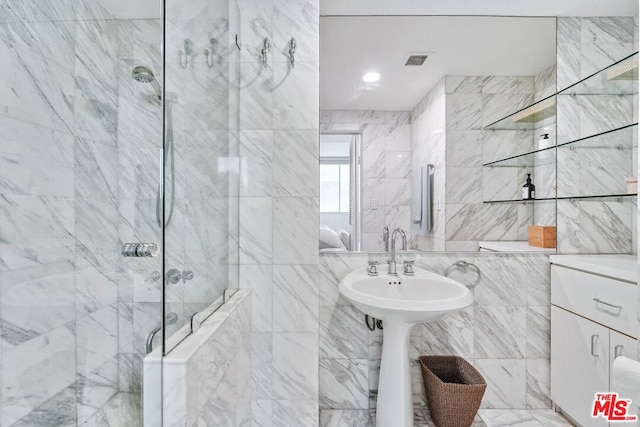 bathroom with a tile shower and tile walls