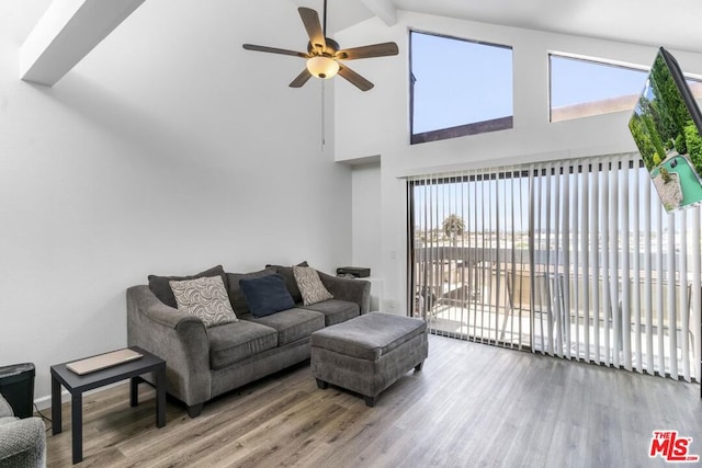 living room featuring ceiling fan, wood-type flooring, and vaulted ceiling with beams