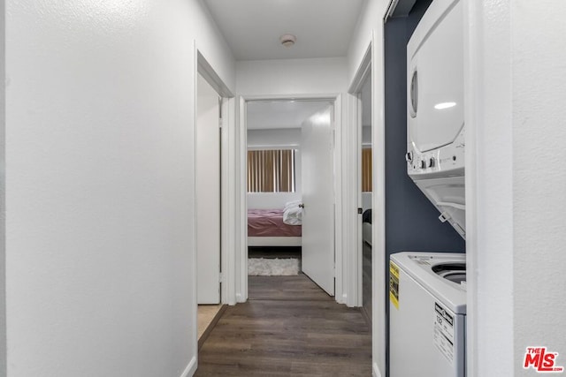 laundry room featuring dark hardwood / wood-style floors and stacked washing maching and dryer