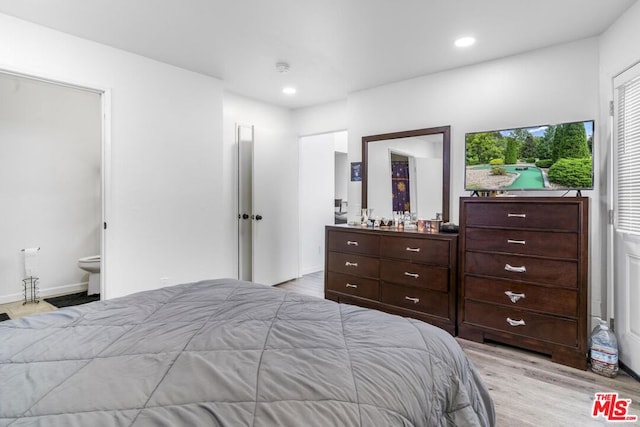 bedroom with ensuite bathroom and light hardwood / wood-style flooring