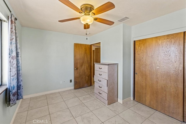 unfurnished bedroom featuring a closet, light tile patterned floors, and ceiling fan