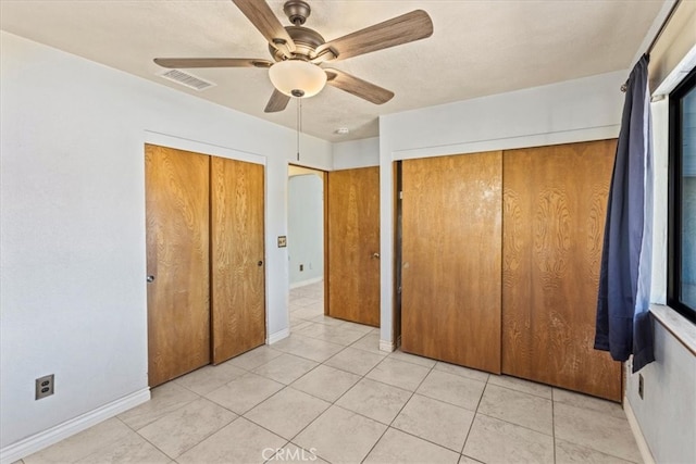 unfurnished bedroom featuring light tile patterned flooring and ceiling fan