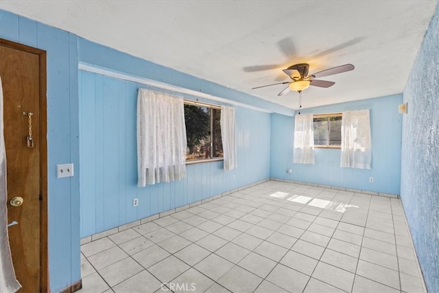 unfurnished room with light tile patterned floors and ceiling fan