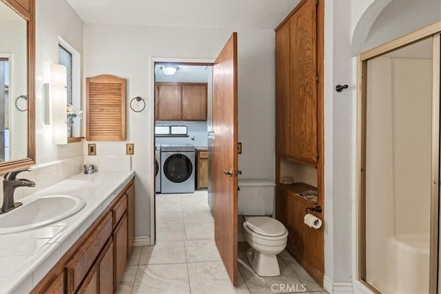 bathroom featuring tile patterned floors, toilet, independent washer and dryer, vanity, and an enclosed shower