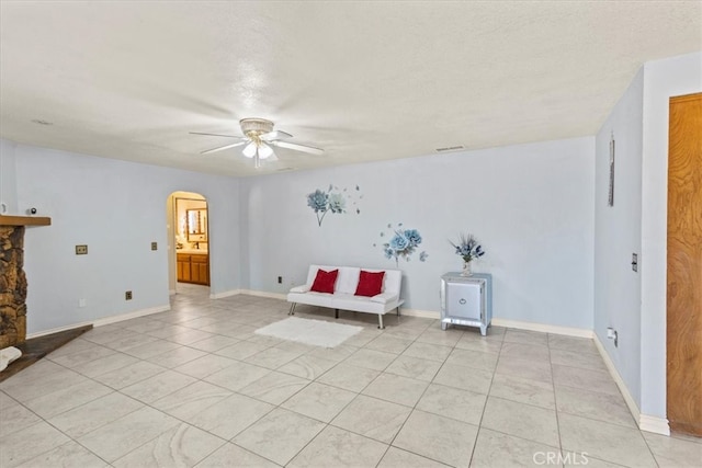 unfurnished room with a textured ceiling, light tile patterned floors, and ceiling fan