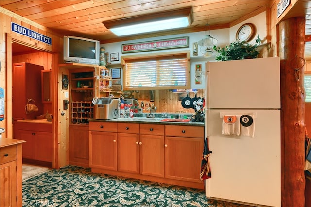 kitchen with wooden walls, crown molding, wooden ceiling, and white refrigerator