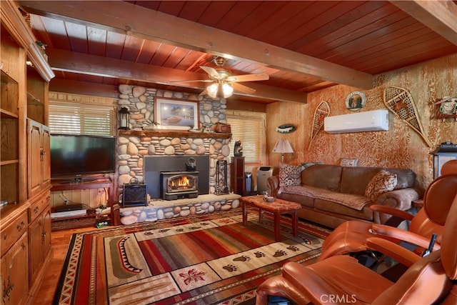 living room featuring beam ceiling, ceiling fan, wood-type flooring, an AC wall unit, and a fireplace