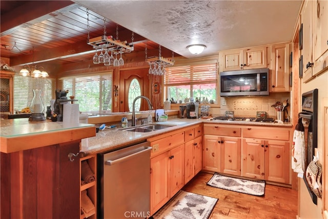 kitchen with appliances with stainless steel finishes, light hardwood / wood-style flooring, a healthy amount of sunlight, and sink