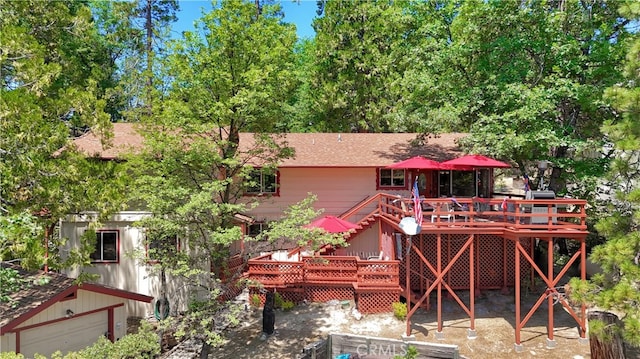 rear view of property with a deck and an outdoor structure