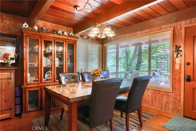 dining room featuring beam ceiling, hardwood / wood-style flooring, an inviting chandelier, and wooden ceiling