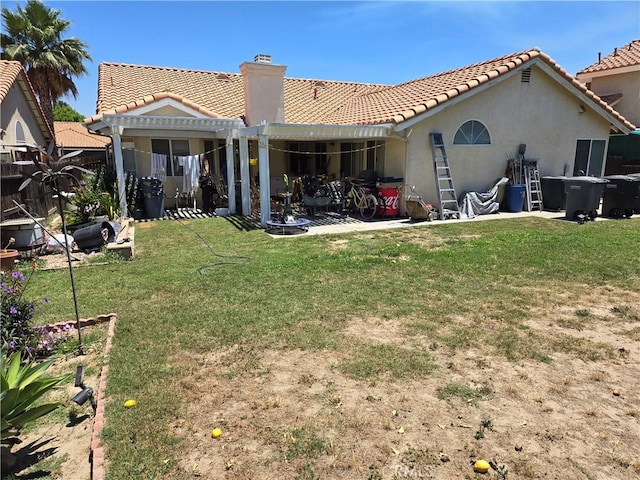 back of property featuring a pergola and a lawn