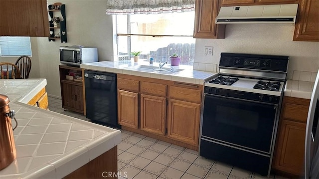 kitchen with extractor fan, sink, tile countertops, and black appliances