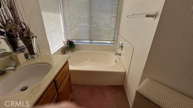 bathroom with vanity and a tub