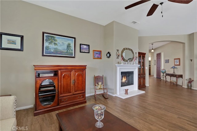 living room featuring ceiling fan and dark hardwood / wood-style flooring