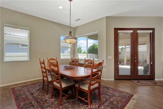 dining space with french doors and dark wood-type flooring