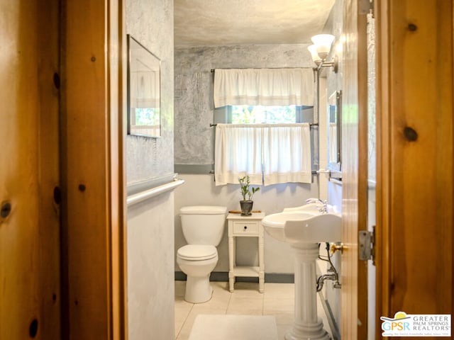 bathroom with toilet and tile patterned floors