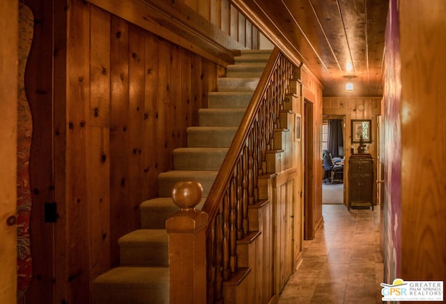 stairs with wood walls and wooden ceiling