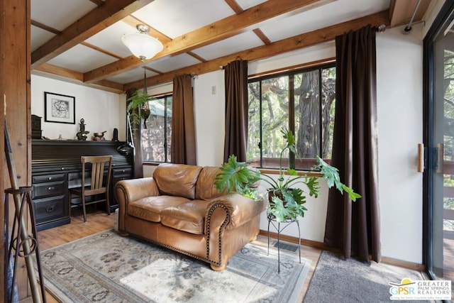 sitting room featuring a wealth of natural light, beam ceiling, and light wood-type flooring