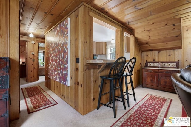 bar featuring wood ceiling, wood walls, lofted ceiling, and light carpet