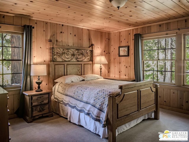 carpeted bedroom with wooden walls and wooden ceiling