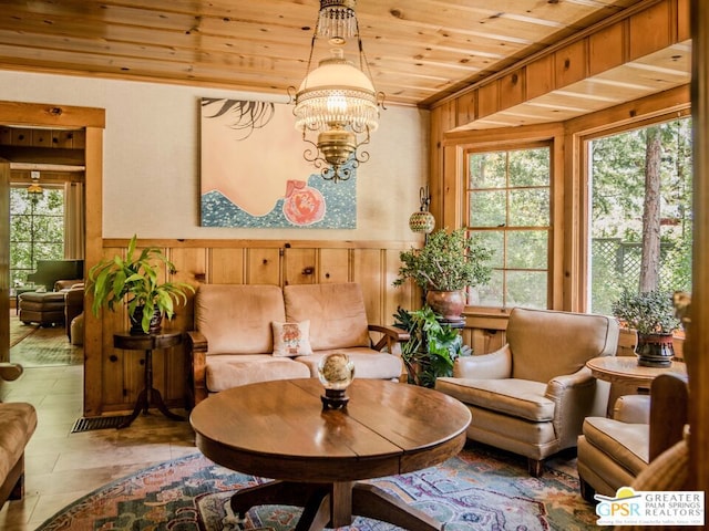 living area with wood ceiling, a notable chandelier, and wooden walls