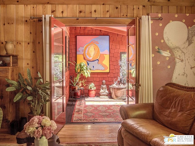 sitting room featuring hardwood / wood-style flooring and wood walls