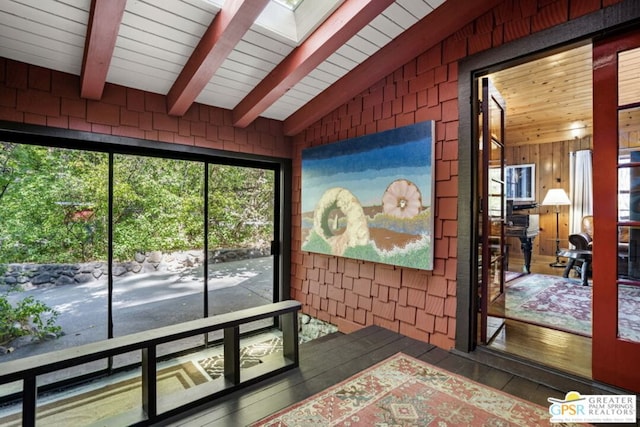 sunroom / solarium with lofted ceiling with skylight and wooden ceiling