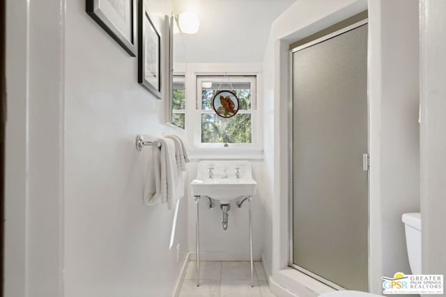 bathroom with toilet and an enclosed shower