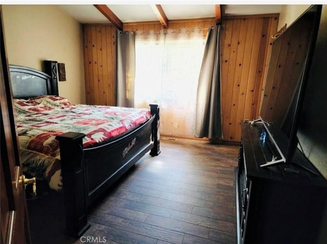 bedroom featuring dark hardwood / wood-style flooring and wooden walls