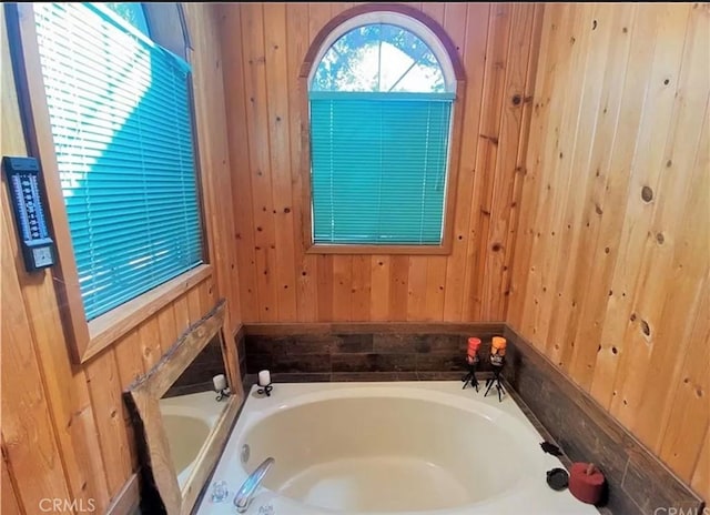 bathroom with wood walls and a tub to relax in