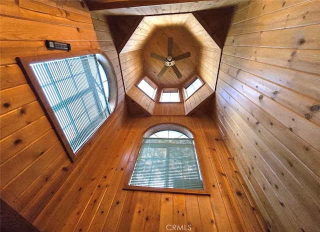 interior details with ceiling fan, wooden walls, and a skylight