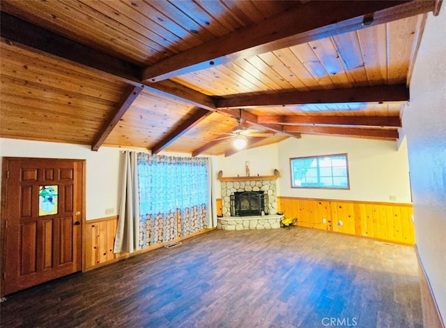 unfurnished living room featuring wood walls, vaulted ceiling with beams, ceiling fan, a fireplace, and wood-type flooring