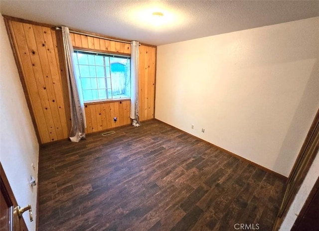 unfurnished bedroom featuring a textured ceiling and dark wood-type flooring