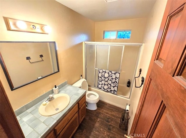 full bathroom with toilet, vanity, enclosed tub / shower combo, and hardwood / wood-style flooring